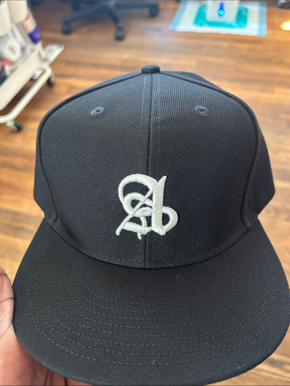 Black Snapback Cap with White Script 'A' Embroidery